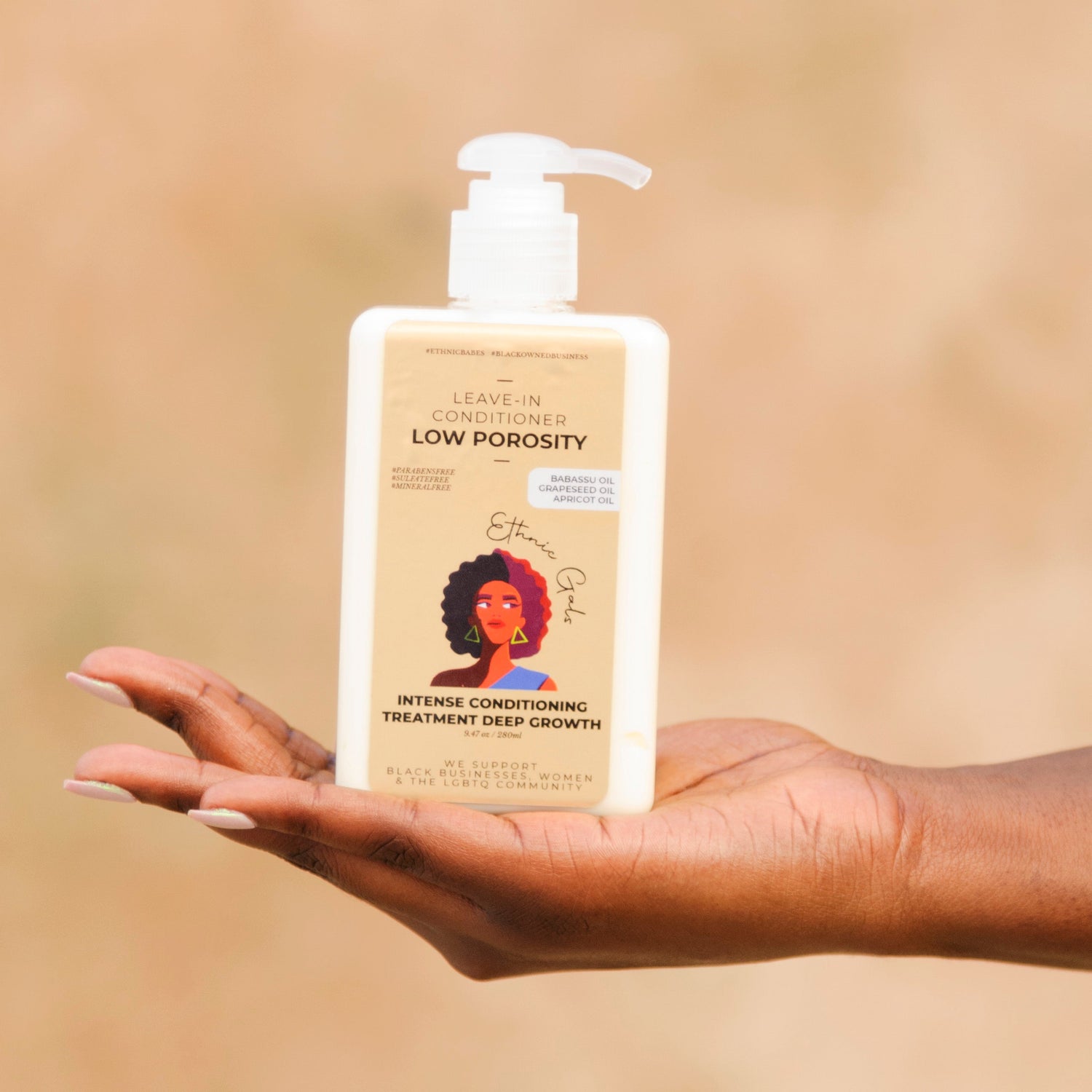 Hand holding a bottle of hair care product with a neutral background
